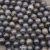Natural iolite gemstone beads displaying rich blue-purple tones and subtle cloudy patterns.