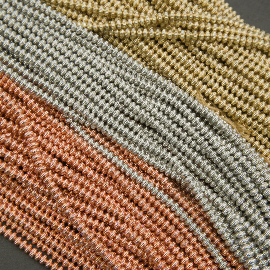 Close-up of woven fabric in brown, green, and beige on a dark background