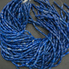 Coiled blue glass beads on a gray background