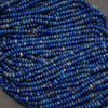 Multiple strands of lapis lazuli rondelle beads showcasing deep ultramarine blue, gray matrix, and golden pyrite inclusions.