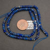 Lapis lazuli rondelle gemstone beads with natural variations in royal blue, navy, and gray for handmade jewelry.