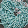 A bundle of smooth round larimar bead strands with Tejas Beads tags