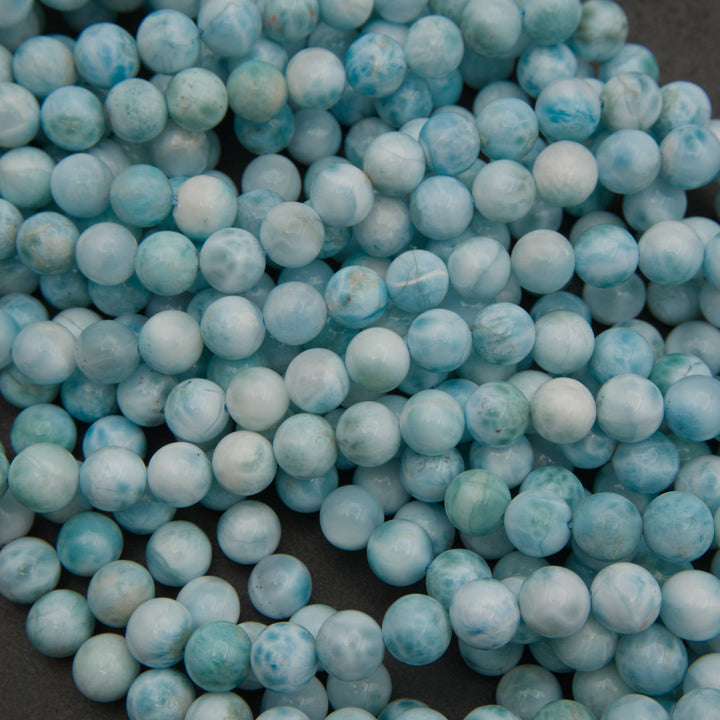 Strands of smooth round larimar beads in light aqua, sky blue and white