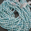 A bundle of smooth round larimar bead strands with Tejas Beads tags