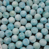 Close-up of smooth round larimar beads in light aqua with white turtleback patterns