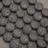 Black lava stone coin beads with a matte finish and naturally porous volcanic texture for jewelry making.