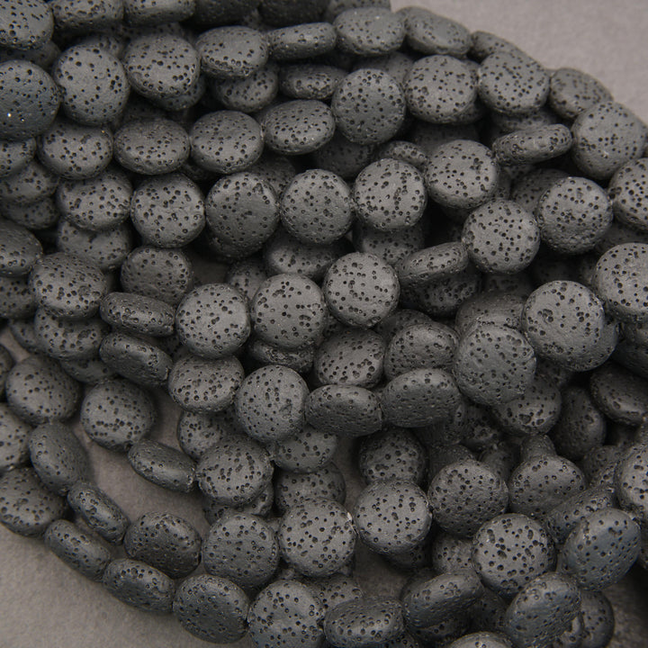 Natural black lava stone coin gemstone beads with a textured matte finish for handmade bracelets and necklaces.