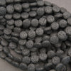 Natural black lava stone coin gemstone beads with a textured matte finish for handmade bracelets and necklaces.