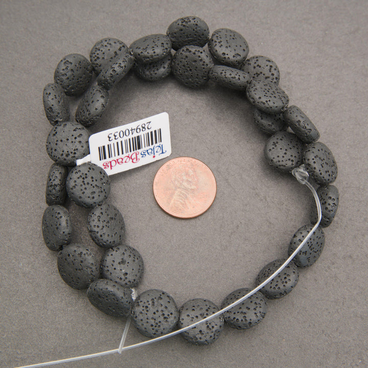 Close-up of black lava rock coin beads featuring rounded, flattened shapes and distinctive volcanic pitting.