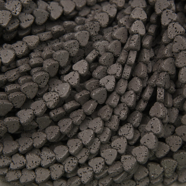Black lava stone heart beads with a matte finish and naturally porous volcanic texture for jewelry making.