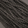 Close-up of matte black lava rock heart beads featuring natural pitting and distinctive surface textures.