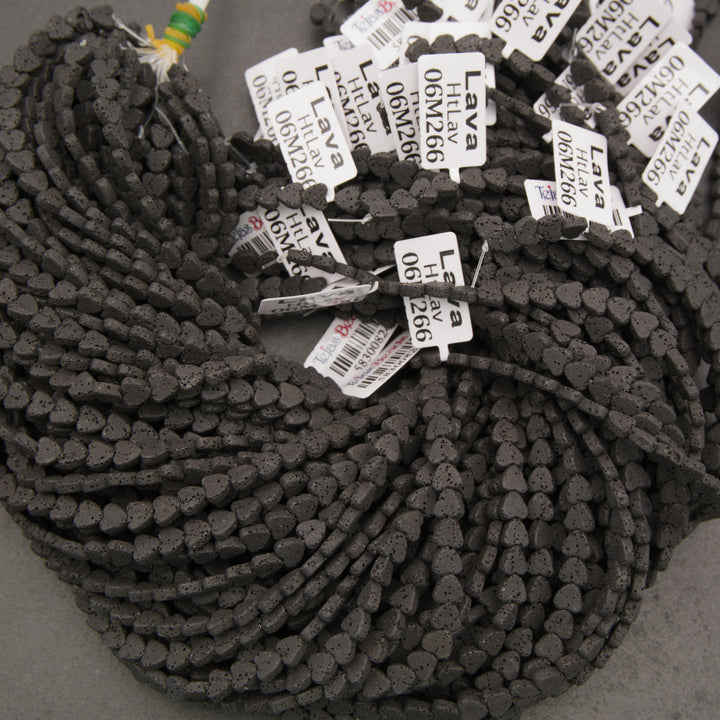 Natural black lava stone heart beads showcasing tiny volcanic pores and a rustic matte appearance.
