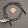 1. Strand of black lava stone heart beads displayed beside a penny for size reference, showing natural volcanic texture.