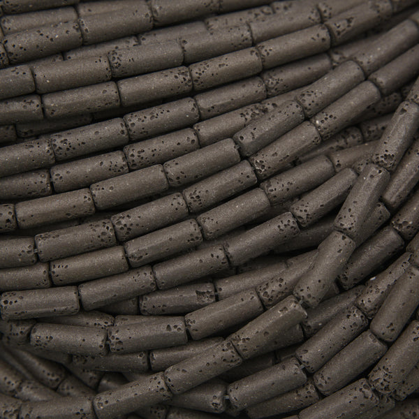 Natural black lava stone tube beads with a matte finish and porous volcanic texture for jewelry making.