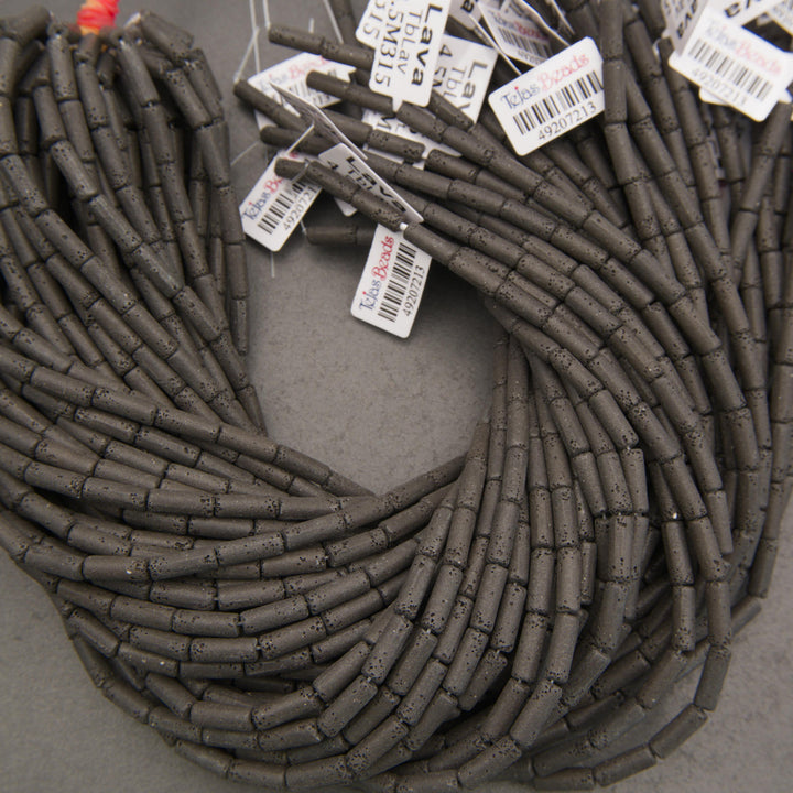 Black volcanic lava stone cylinder beads featuring a rustic matte finish and distinctive porous texture.