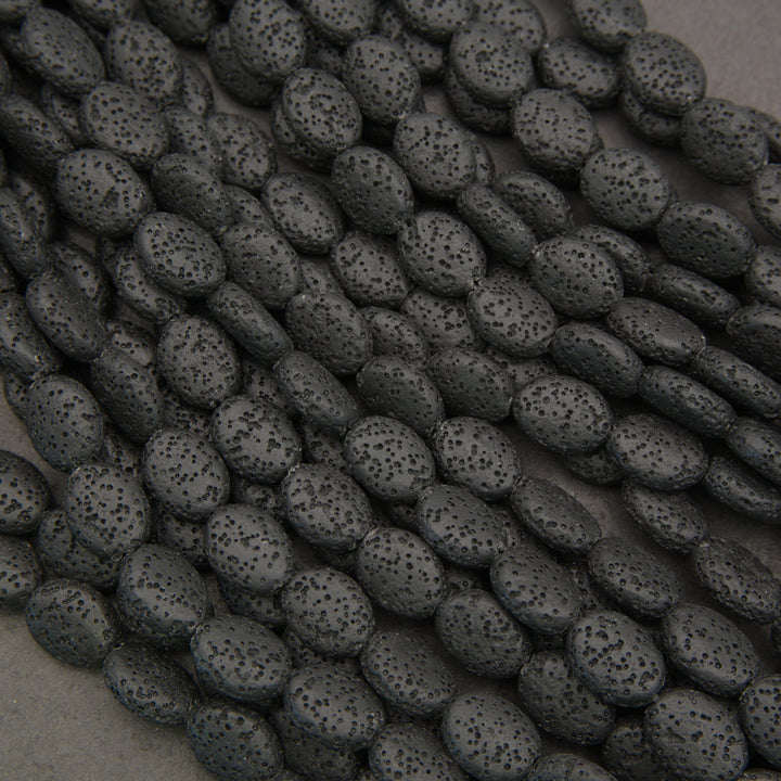 Close-up of black lava rock oval beads featuring natural pitting and a distinctive charcoal-black surface.