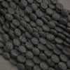 Close-up of black lava rock oval beads featuring natural pitting and a distinctive charcoal-black surface.