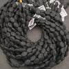 Matte black lava stone oval gemstone beads showcasing natural volcanic pores and unique surface textures.