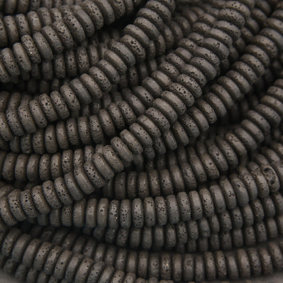 Natural black lava stone rondelle gemstone beads with a rustic texture for handmade bracelets and necklaces.