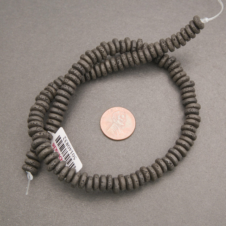 Black lava stone rondelle disk beads with a matte finish and naturally porous volcanic texture for jewelry making.