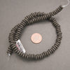 Black lava stone rondelle disk beads with a matte finish and naturally porous volcanic texture for jewelry making.