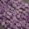 Close-up of rough raw lavender amethyst nugget beads with frosted faces and deeper purple patches