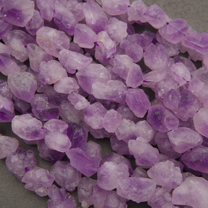 Close-up of frosted rough raw lavender amethyst nugget beads in soft lilac and purple