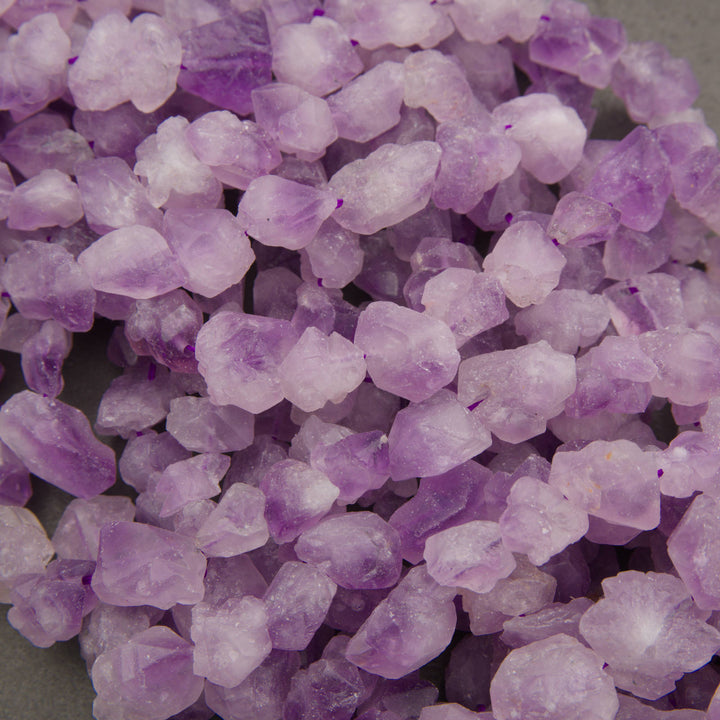 Strands of rough raw lavender amethyst nuggets in pale lavender with deeper purple patches