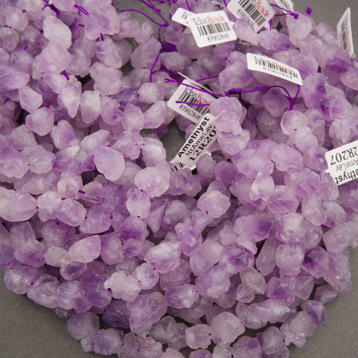 A bundle of rough raw lavender amethyst nugget strands with Tejas Beads tags