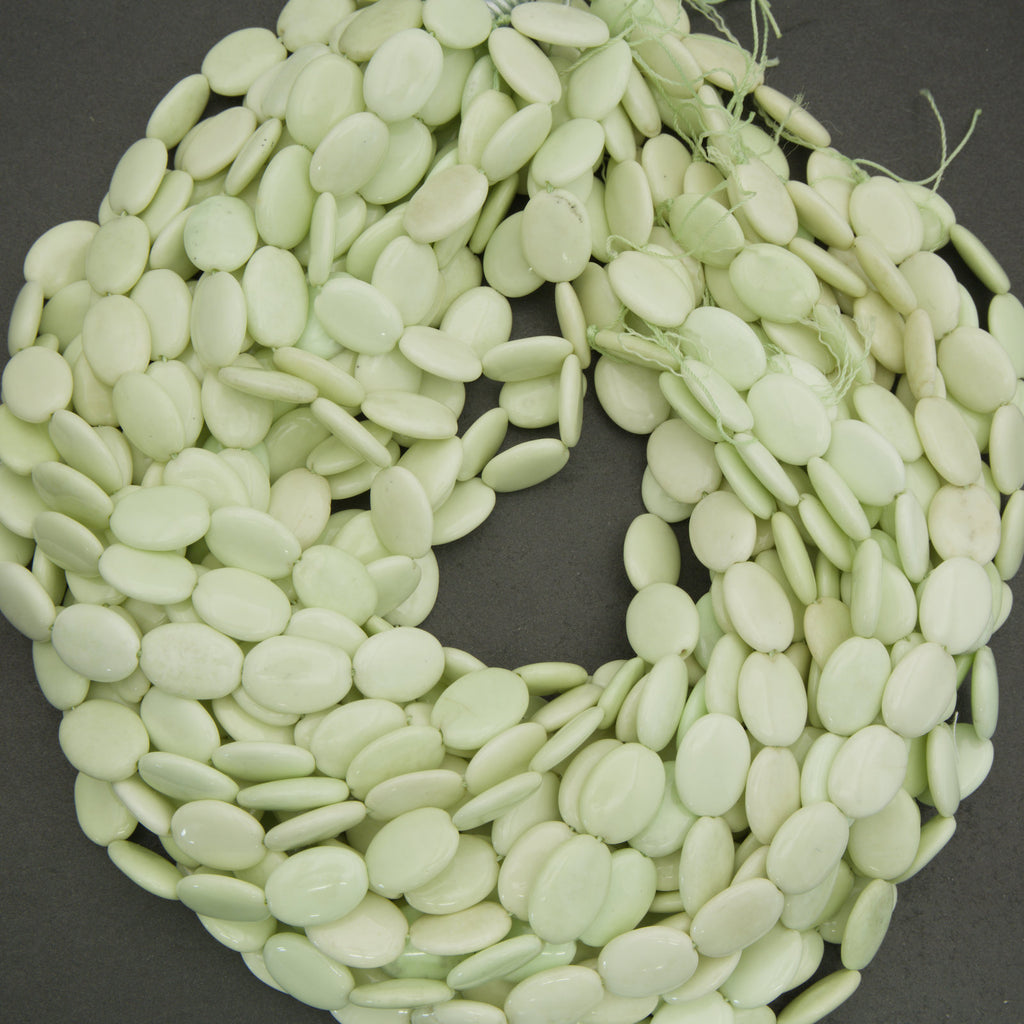 Light green oval beads on a dark background