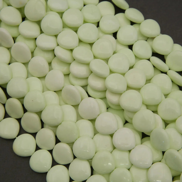 Close-up of light green beads on a dark surface