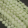 Close-up of light green beads on a dark surface