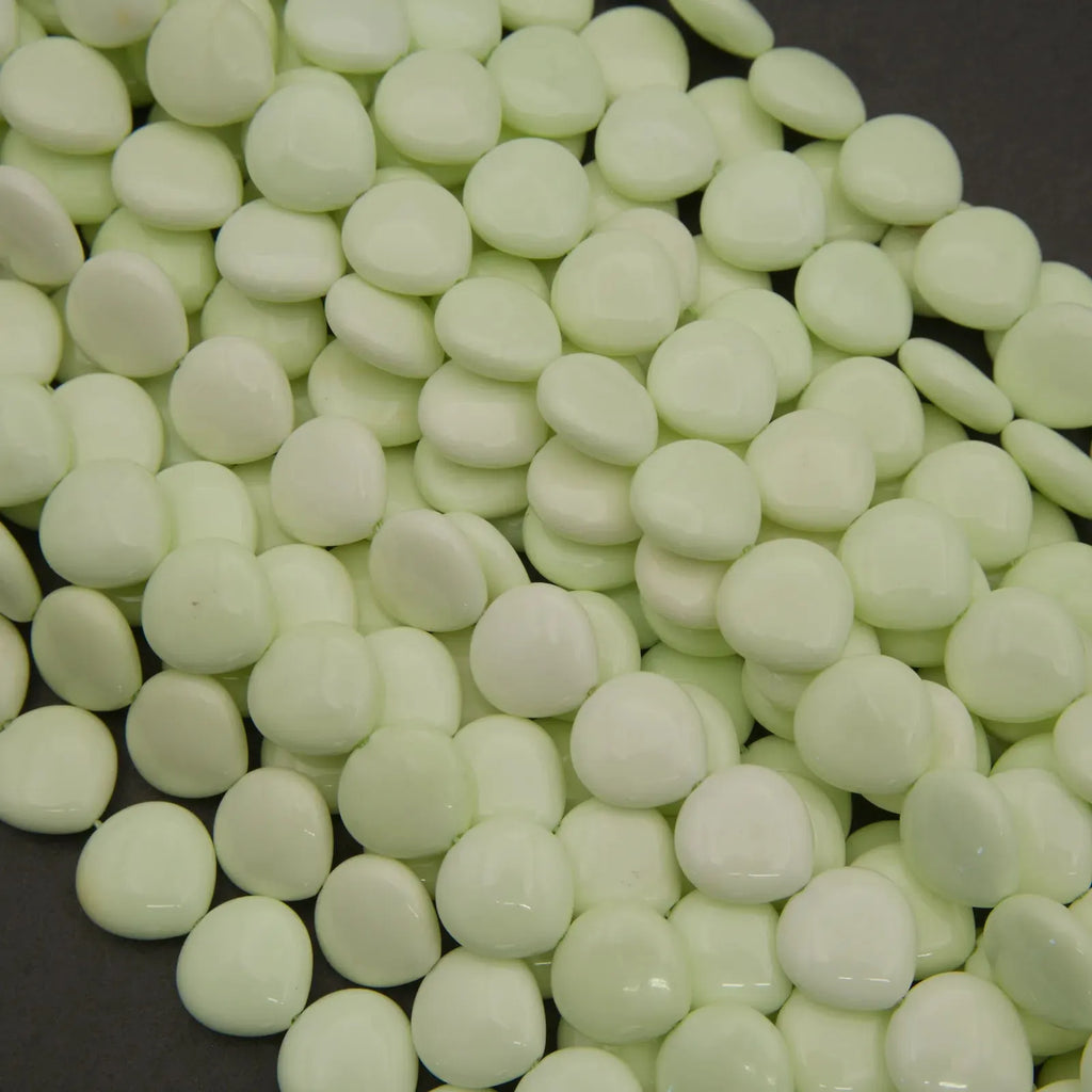 Close-up of light green beads on a dark surface