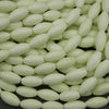 Close-up of light green oval beads on a black background