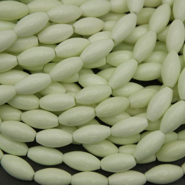 Close-up of light green oval beads on a black background