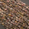 A heap of faceted leopard skin jasper oval bead strands in dusty rose, tan and gray