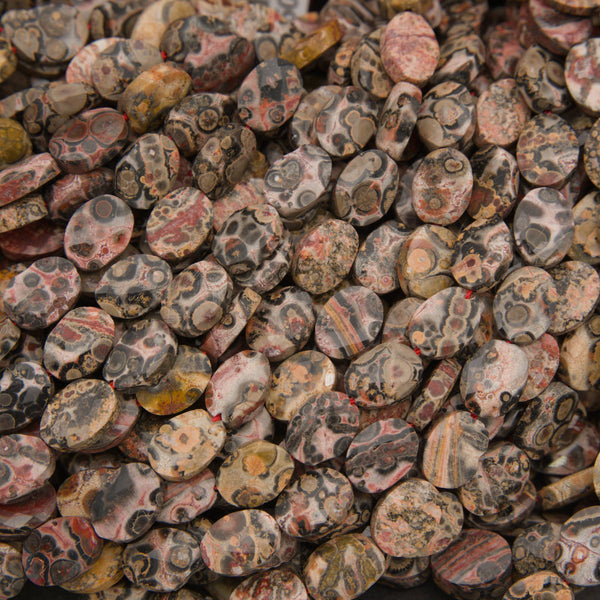 Close-up of faceted leopard skin jasper oval beads showing pink, tan and gray with dark leopard spots