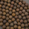 A close-up pile of round wooden beads with a natural, swirling grain pattern in shades of brown and tan.