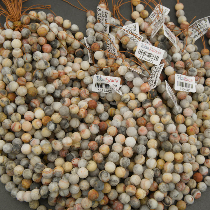 Close-up of assorted beads with visible labels on a gray background