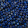 A close-up pile of small round blue beads with natural white and gray marbling, filling the entire frame.