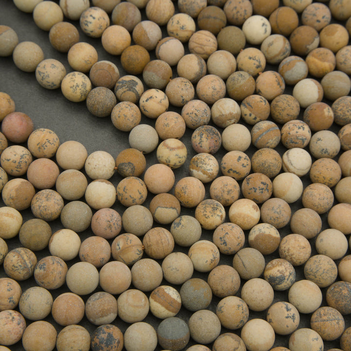 Close-up of beige and brown marbled beads on a dark surface