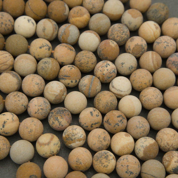 Close-up of beige and brown marbled beads on a dark background