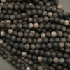 Close-up of black and gray spherical beads on a textured surface