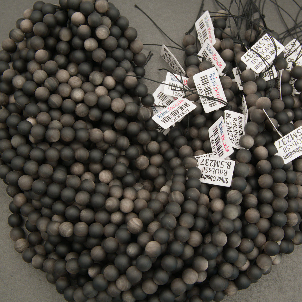 Black beads with price tags on a gray surface