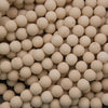 A close-up pile of small, round, off-white ceramic beads or balls filling the frame.
