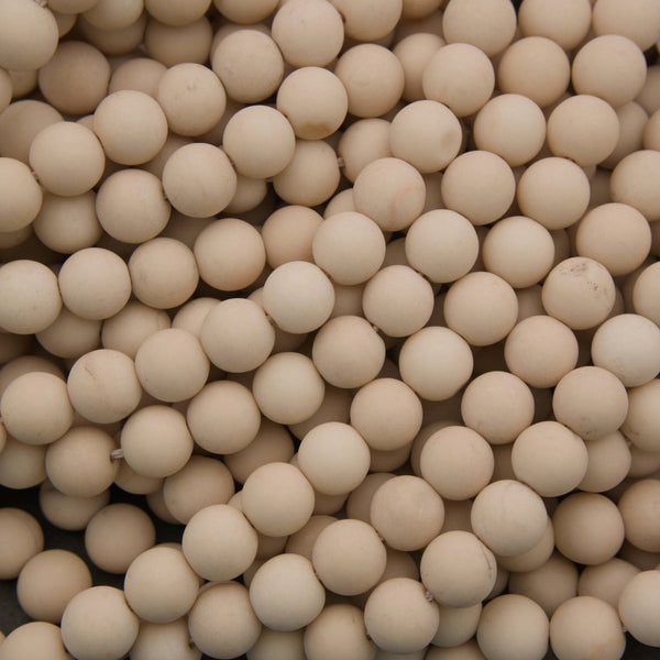 A close-up pile of small, round, off-white ceramic beads or balls filling the frame.