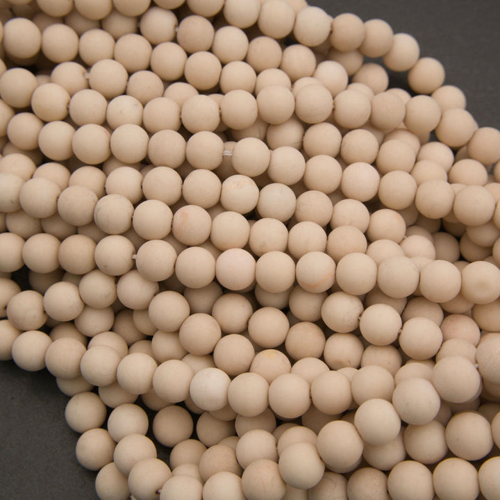 A pile of small, round, off-white ceramic beads or pellets on a dark gray background.