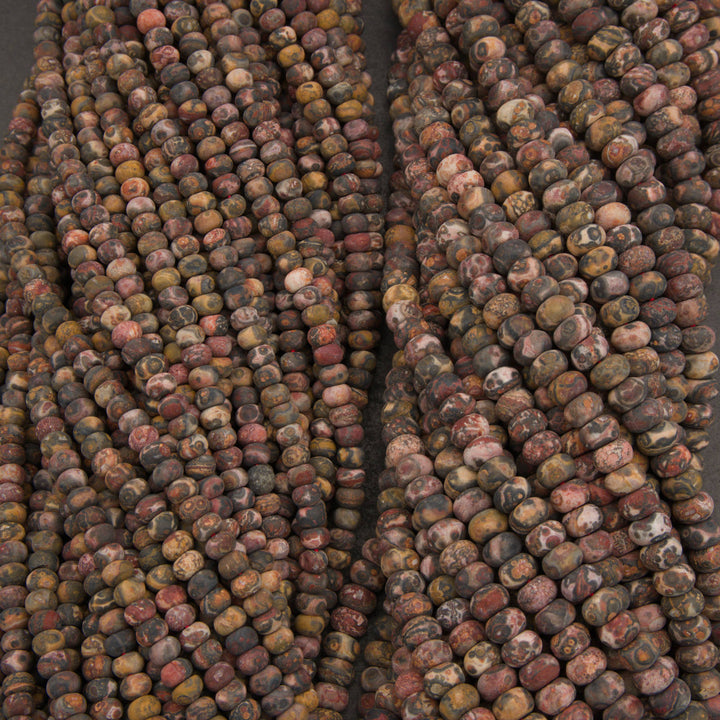 Multiple strands of round stone beads in earthy marbled colors, including brown, red, gray, black, and beige, arranged vertically.