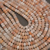 Peach Aventurine gemstone bead strands in assorted peach and ivory shades.