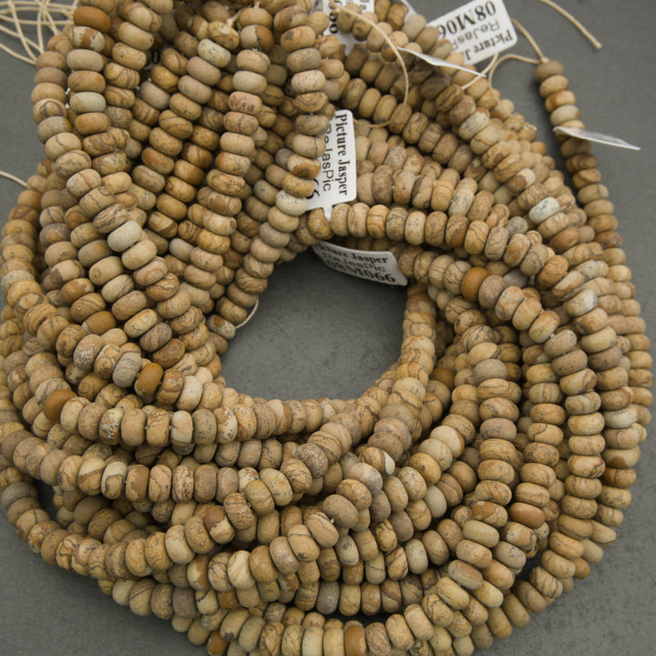 String of beige beads with visible texture on a gray background